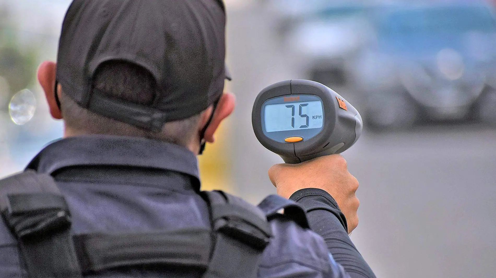 policia vial apunta radar de velocidad 